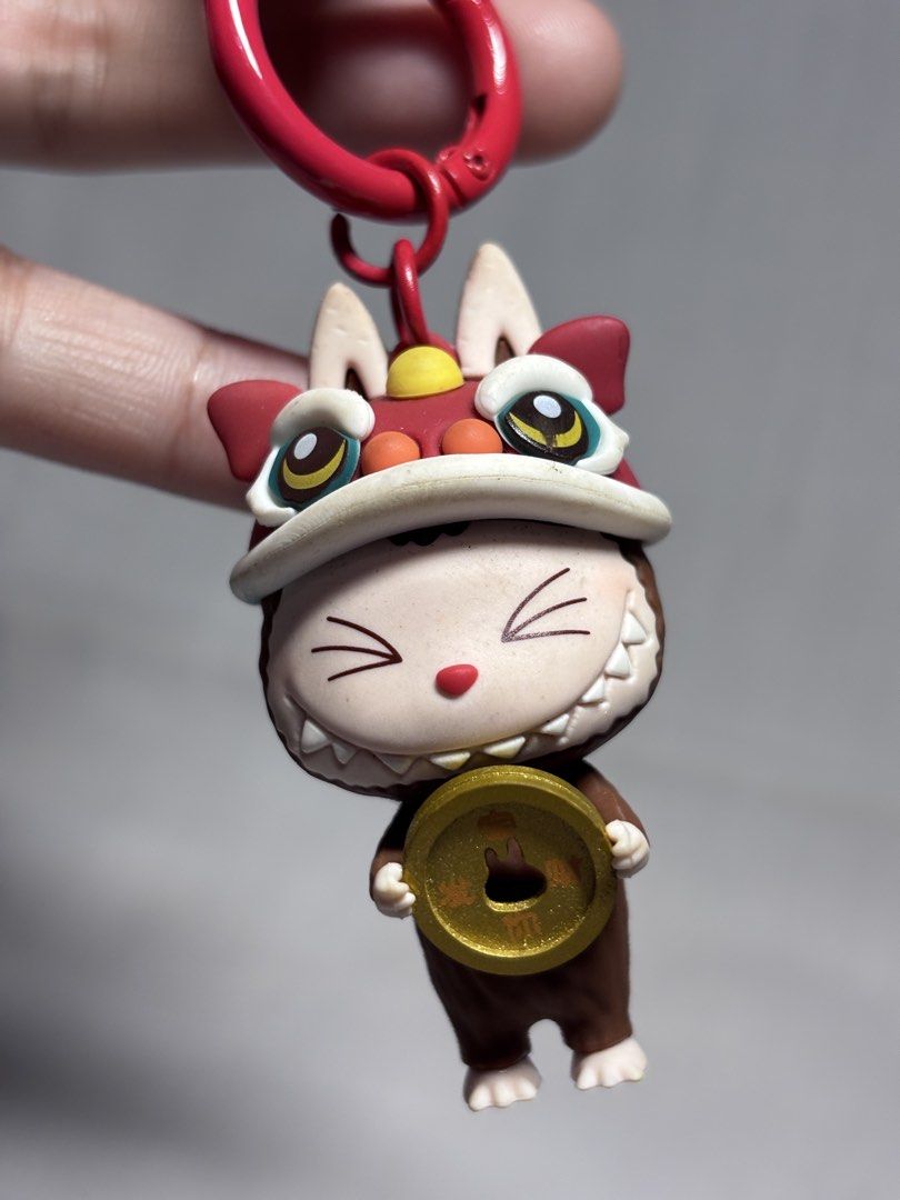 Cute Cat Lion Dance Keychain with Coin (Category: Character Goods) located in Sablan. Submitted by 21enygrace.ph (Listing ID 1462950365, Image 2). Description: - Adorable cat keychain - Dressed in a festive lion dance costume - Holding a lucky gold coin - Comes with a red rope and clasp for easy attachment - Ideal for decorating bags, keys, or backpacks - Makes a unique and thoughtful gift - Adds a touch of fun and good fortune to your accessorie