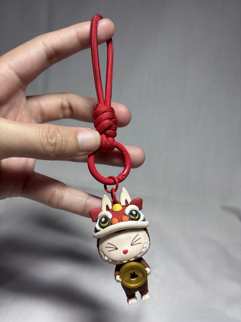 Cute Cat Lion Dance Keychain with Coin (Category: Character Goods) located in Sablan. Submitted by 21enygrace.ph (Listing ID 1462950365, Image 1). Description: - Adorable cat keychain - Dressed in a festive lion dance costume - Holding a lucky gold coin - Comes with a red rope and clasp for easy attachment - Ideal for decorating bags, keys, or backpacks - Makes a unique and thoughtful gift - Adds a touch of fun and good fortune to your accessorie