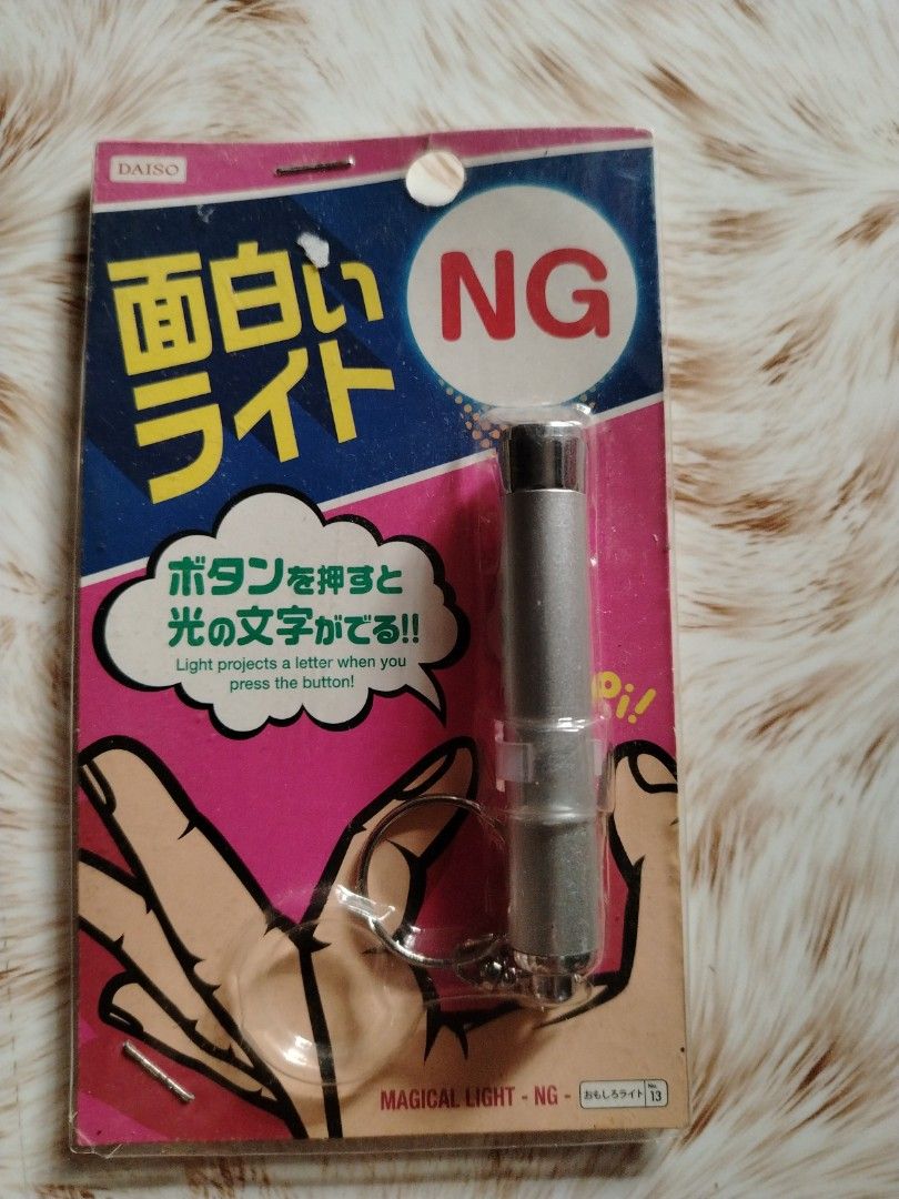 Daiso Magical Light - NG Projector Keychain (Category: Projectors) located in Cavite. Submitted by 1324abegai53000 (Listing ID 1462967145, Image 1). Description: - Daiso NG projector light keychain - Projects a letter when button is pressed - Comes with keychain ring - Fun gadget for parties or laughs - Still in original packaging.
