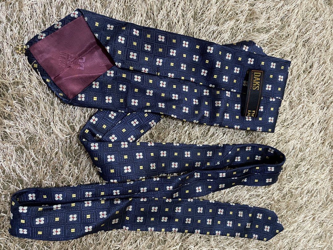 Daks London Silk Tie - Navy Blue Geometric Pattern (Category: Ties) located in Bulacan. Submitted by rich2545 (Listing ID 1462905648, Image 3). Description: - Classic navy blue silk tie from Daks London. - Features a repeating geometric pattern. - Accents of red, white, and yellow. - Ideal for formal or business occasions. - Adds sophistication to any outfit..
