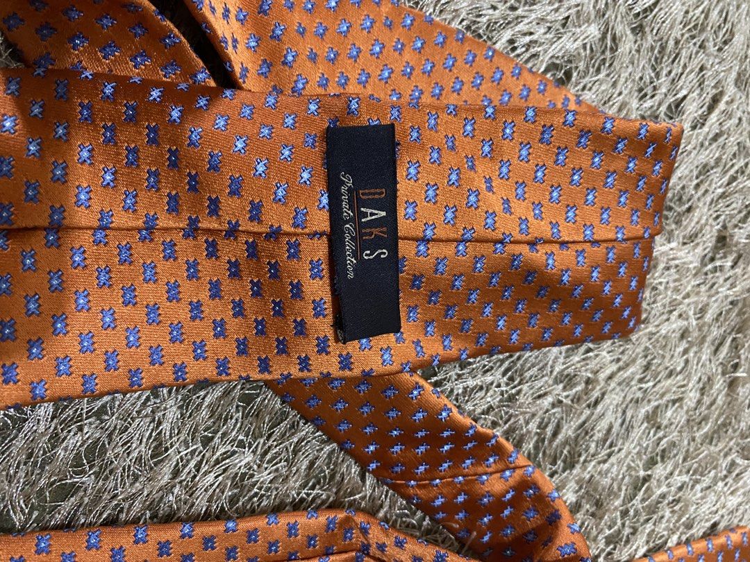 DAKS Silk Tie - Orange with Blue Pattern (Category: Ties) located in Bulacan. Submitted by rich2545 (Listing ID 1462902940, Image 3). Description: - Elegant orange silk tie - Features a small, stylish blue pattern - Authentic DAKS logo on the back - Versatile accessory to enhance any outfit - A must-have addition to your collection.