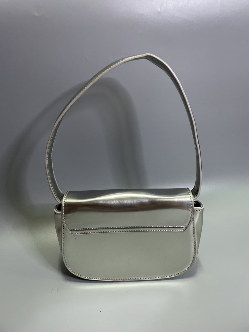 Diesel 1DR shoulder Silver bag (Category: Luxury Bags & Wallets) located in Bocaue. Submitted by mosthighcollective (Listing ID 1463051514, Image 2). Description: Diesel 1DR shoulder Silver bag Product Details * Leather shoulder bag in a metallic finish. * Top handle * Detachable adjustable shoulder strap * Magnetic-fastening front flap closure * Front logo plaque * One main compartment * 100% Leather * Color: Silver * No issue .