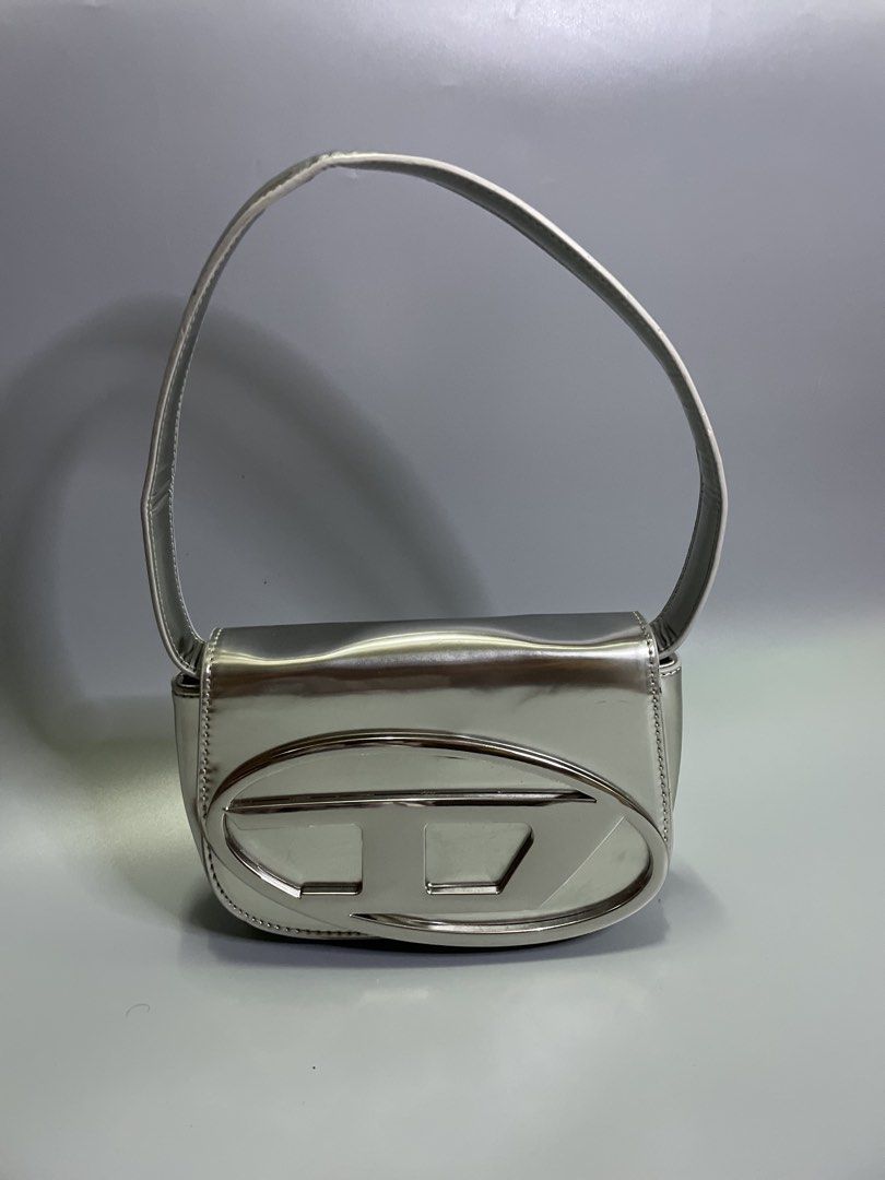 Diesel 1DR shoulder Silver bag (Category: Luxury Bags & Wallets) located in Bocaue. Submitted by mosthighcollective (Listing ID 1463051514, Image 1). Description: Diesel 1DR shoulder Silver bag Product Details * Leather shoulder bag in a metallic finish. * Top handle * Detachable adjustable shoulder strap * Magnetic-fastening front flap closure * Front logo plaque * One main compartment * 100% Leather * Color: Silver * No issue .