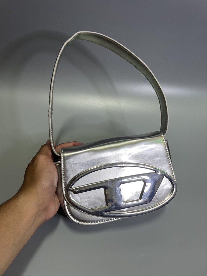 Diesel 1DR shoulder Silver bag (Category: Luxury Bags & Wallets) located in Bocaue. Submitted by mosthighcollective (Listing ID 1463051514, Image 3). Description: Diesel 1DR shoulder Silver bag Product Details * Leather shoulder bag in a metallic finish. * Top handle * Detachable adjustable shoulder strap * Magnetic-fastening front flap closure * Front logo plaque * One main compartment * 100% Leather * Color: Silver * No issue .