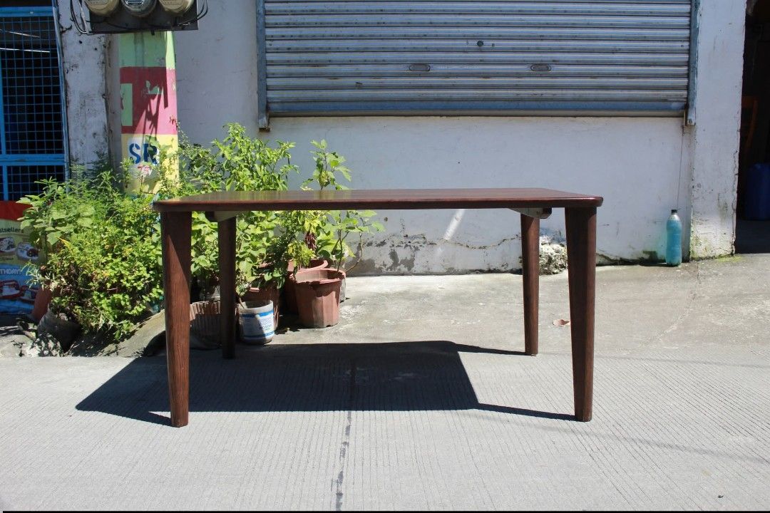 Dining Table (Category: Tables & Sets) located in Meycauayan. Submitted by marygracecasimiro (Listing ID 1463009104, Image 2). Description: CHITANO Mid-Century Modern Dining Table Premium solid wood rectangular dining table with rounded corners, a rich dark wood finish and slim tapered legs. Its clean, elegant design is perfect for dining areas, modern homes or minimalist interiors L:53 ¼ • W:34 ¾ • H:27 ¼ inches 8,700 pesos only💚.