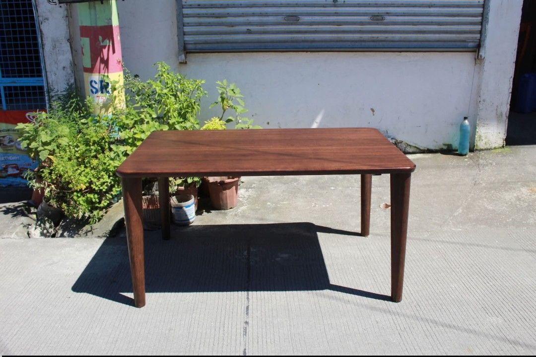 Dining Table (Category: Tables & Sets) located in Meycauayan. Submitted by marygracecasimiro (Listing ID 1463009104, Image 1). Description: CHITANO Mid-Century Modern Dining Table Premium solid wood rectangular dining table with rounded corners, a rich dark wood finish and slim tapered legs. Its clean, elegant design is perfect for dining areas, modern homes or minimalist interiors L:53 ¼ • W:34 ¾ • H:27 ¼ inches 8,700 pesos only💚.