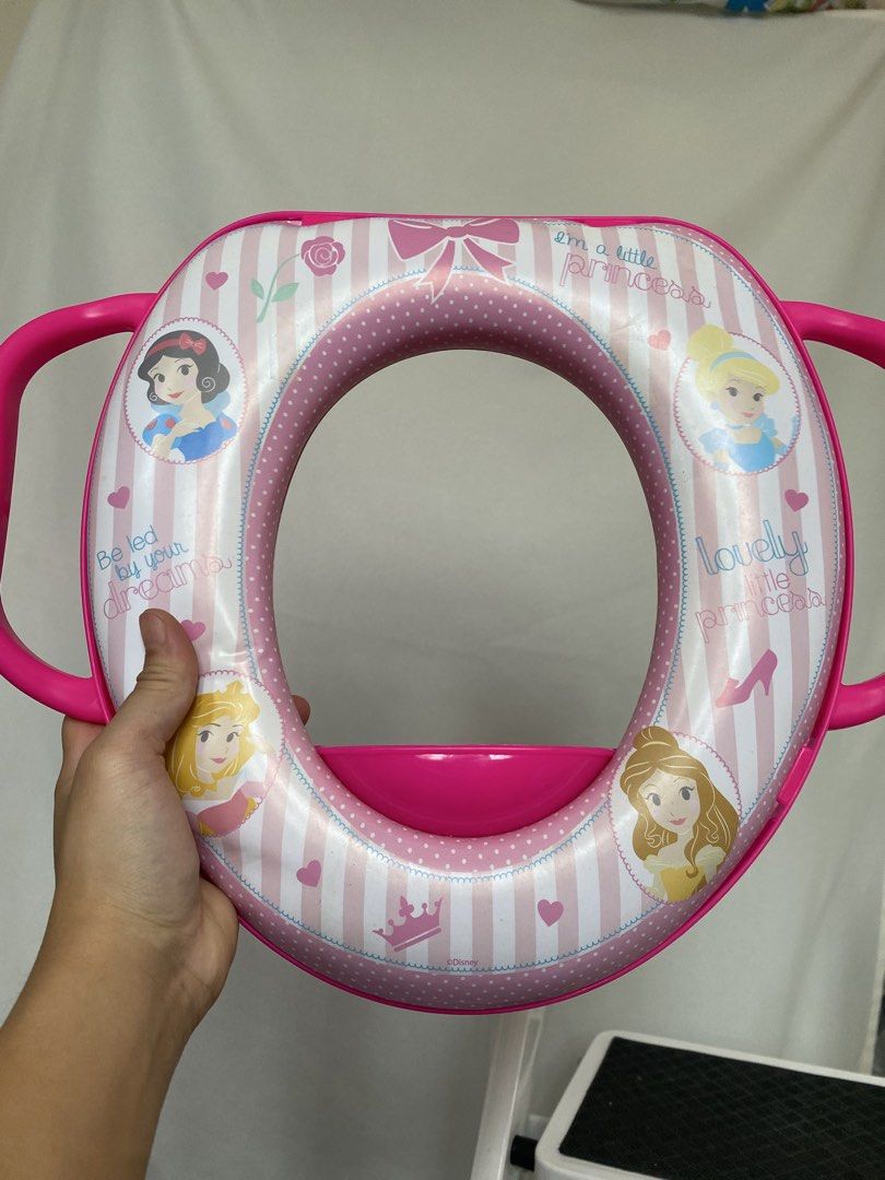 Disney Princess Potty Training Seat with Handles (Category: Toilet Training) located in Las Pinas. Submitted by makingspace24 (Listing ID 1462911048, Image 1). Description: - Make potty training magical with this cute Disney Princess potty seat! - Features beloved princesses: Snow White, Cinderella, Aurora, and Belle. - Adorable pink and white striped design with charming hearts and crowns. - Built-in handles provide extra stability and confidenc