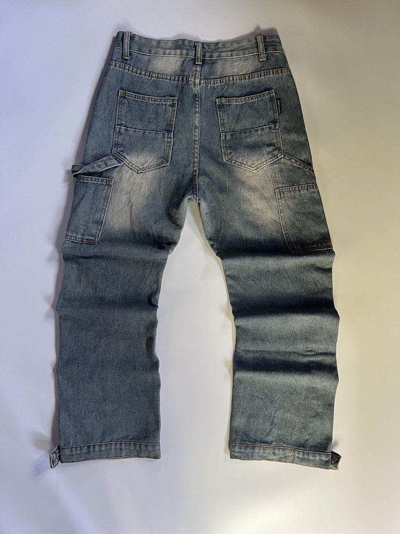 Distressed Denim Carpenter Jeans with Snap Button Cuffs (Category: Jeans) located in Baler. Submitted by allthrifted31 (Listing ID 1462964185, Image 2). Description: - Light wash denim jeans - Carpenter style with side utility pocket - Distressed detailing - Snap button closure at cuffs - Straight leg fit - Ideal for casual streetwear outfits.