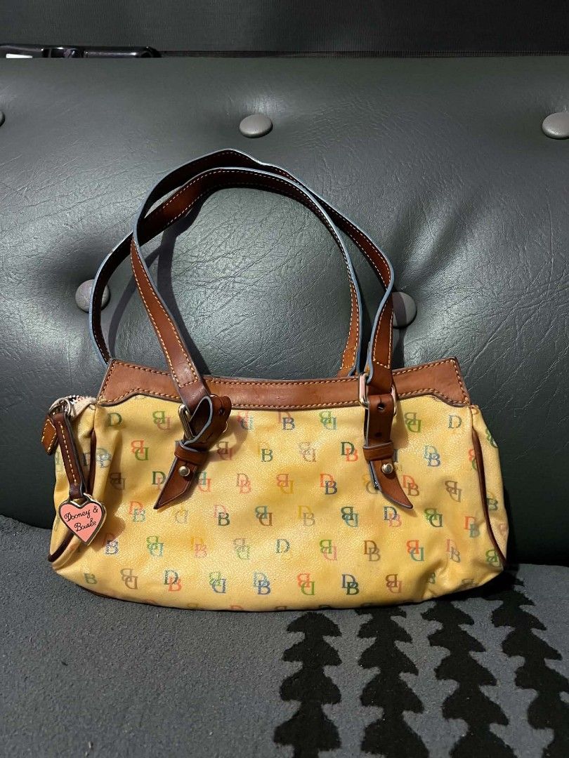 Dooney & Bourke Vintage Tasche (Category: Luxury Bags & Wallets) located in Quezon City. Submitted by all_for_love (Listing ID 1463100531, Image 2). Description: - Cute Dooney & Bourke satchel bag - Classic all-weather leather with multi-color 'DB' monogram - Brown leather trim and handles - Includes signature heart charm - Spacious interior for essentials - Fun and colorful addition to any outfit Dm me for sure buyer .