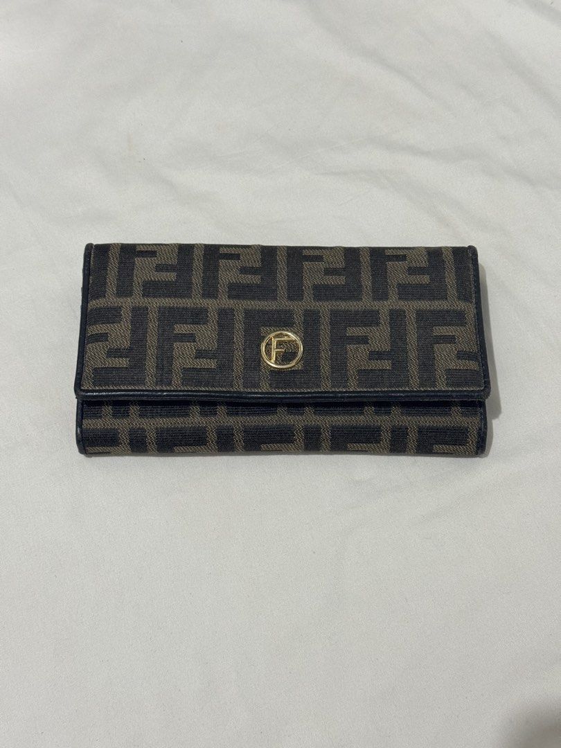Fendi Zucca Canvas Continental Long Wallet (Category: Luxury Bags & Wallets) located in Manila. Submitted by rzkei (Listing ID 1462943870, Image 1). Description: - Authentic Fendi wallet - Classic Zucca canvas pattern - Black leather interior - Zippered coin pocket - Multiple card slots and bill compartments - Gold tone Fendi logo hardware - Secure snap closure 📍Taguig Price is negotiable..