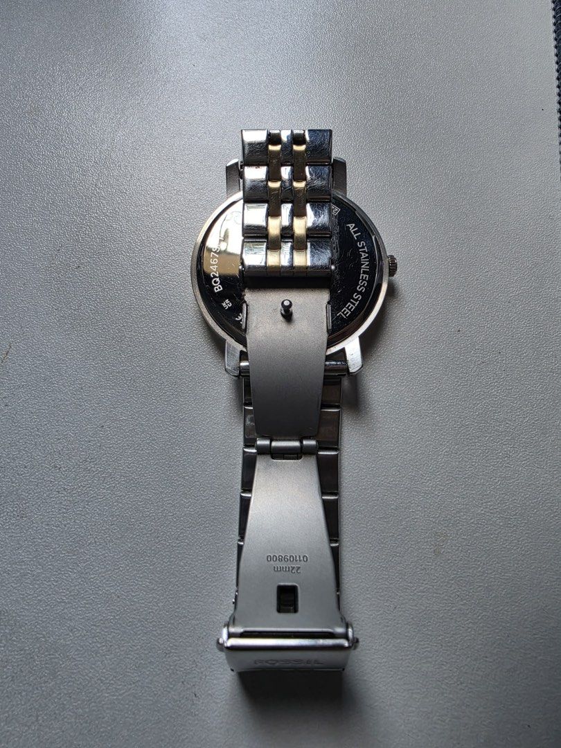 Fossil Watch Two-Tone Stainless Steel (Category: Women's Watches) located in Imus. Submitted by cslek020 (Listing ID 1461624801, Image 3). Description: - Fossil watch with a classic silver and gold two-tone stainless steel band. - Clean white watch face with simple hour markers. - Features a subtle diamond accent at the 12 o'clock position. - Versatile design suitable for everyday wear or dressing up. - Authentic Fossil branding visible on the wa
