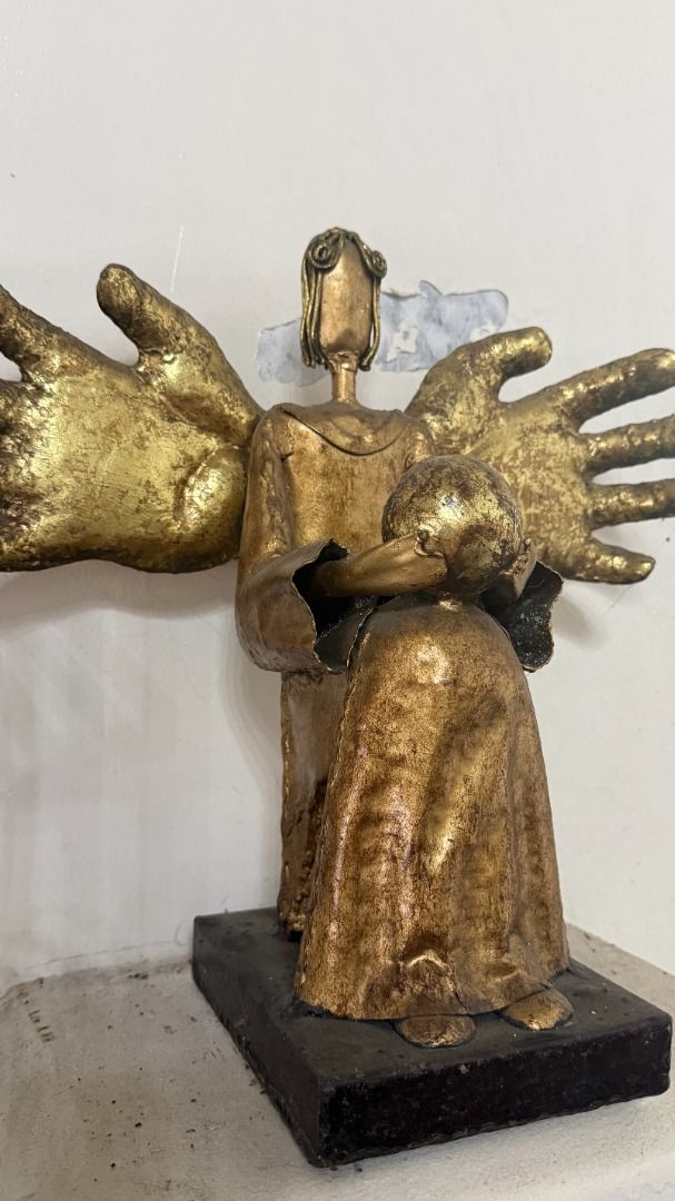 Gilded Metal Angel figurine (Category: Other Home Decor) located in Cainta. Submitted by villa_paraiso (Listing ID 1462957854, Image 3). Description: Unique angel sculpture with multiple hands - featuring a rustic, textured gold finish - Holding a child - Sturdy dark base - Adds character and is a great conversation starter - Ideal for display in any space price is slightly negotiable.