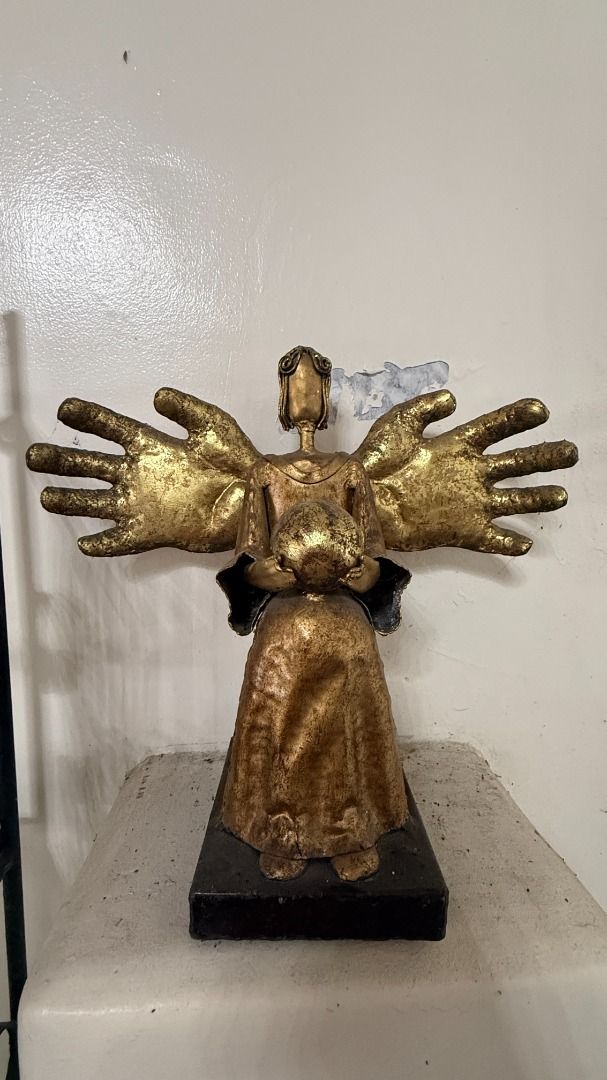 Gilded Metal Angel figurine (Category: Other Home Decor) located in Cainta. Submitted by villa_paraiso (Listing ID 1462957854, Image 1). Description: Unique angel sculpture with multiple hands - featuring a rustic, textured gold finish - Holding a child - Sturdy dark base - Adds character and is a great conversation starter - Ideal for display in any space price is slightly negotiable.