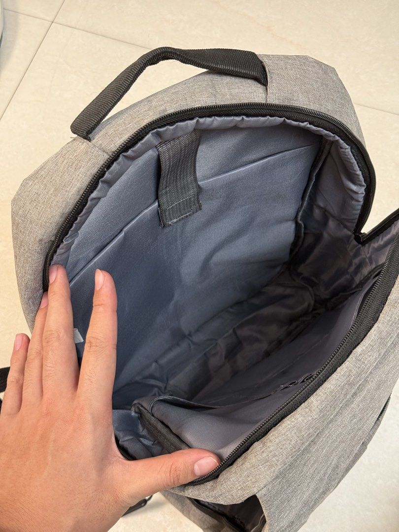 Gray Office Laptop Backpack (Category: Backpacks) located in Paranaque City. Submitted by thrifty_findz (Listing ID 1462969611, Image 2). Description: Streamline your daily routine with this sleek, minimalist heather grey backpack built for work, school, or travel. It features a spacious zippered main compartment, a hidden horizontal front pocket for quick access, and padded adjustable shoulder straps for all-day carrying comfort. Lightweight yet