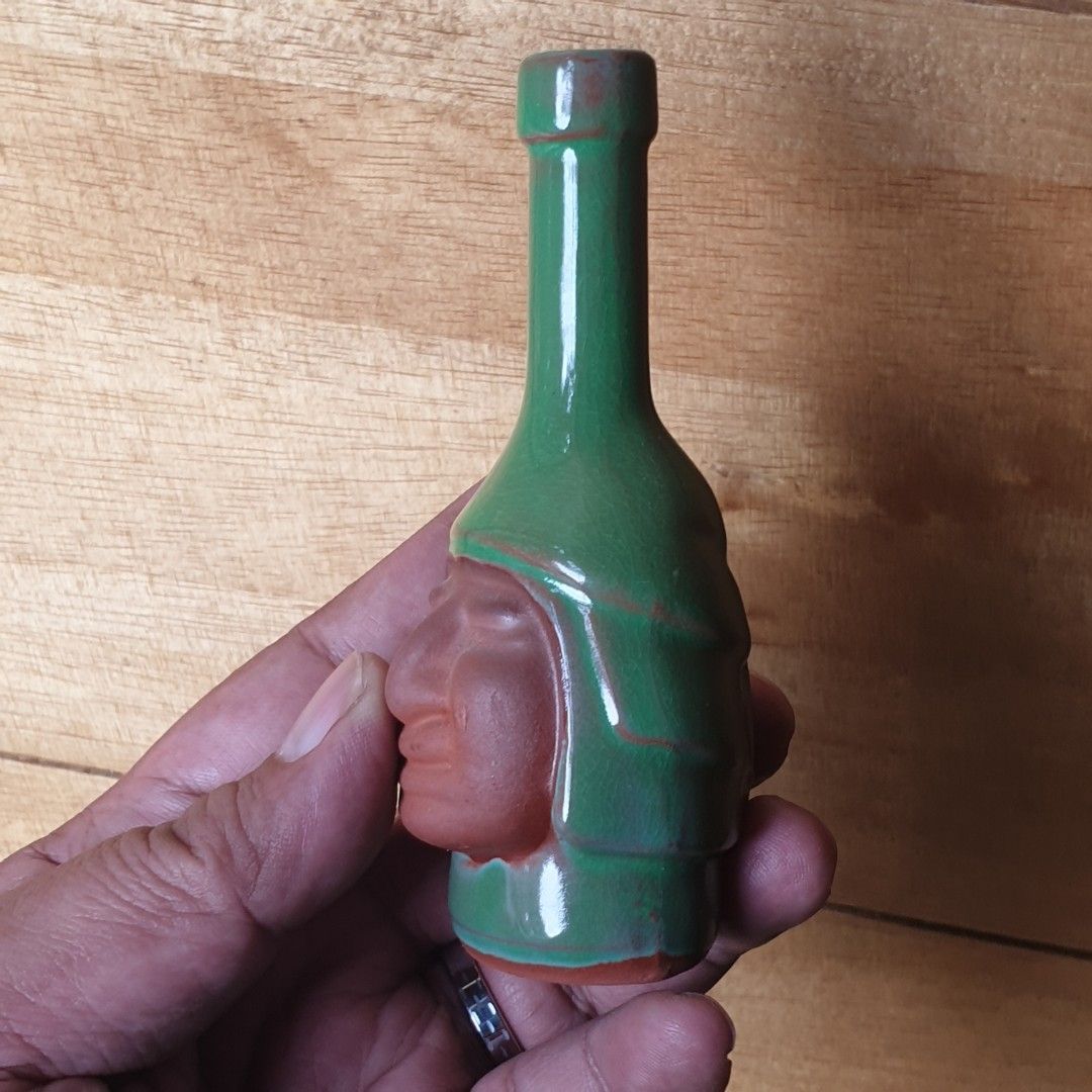 Green Ceramic Bottle with Face Design (Category: Vases & Decorative Bowls) located in Iligan City. Submitted by sariranaw (Listing ID 1463003131, Image 3). Description: - Unique green ceramic - Bottle shape with a carved face - Subtle color variations in glaze - Opening located at the neck - Unglazed terracotta base - Perfect for collectors of quirky items.
