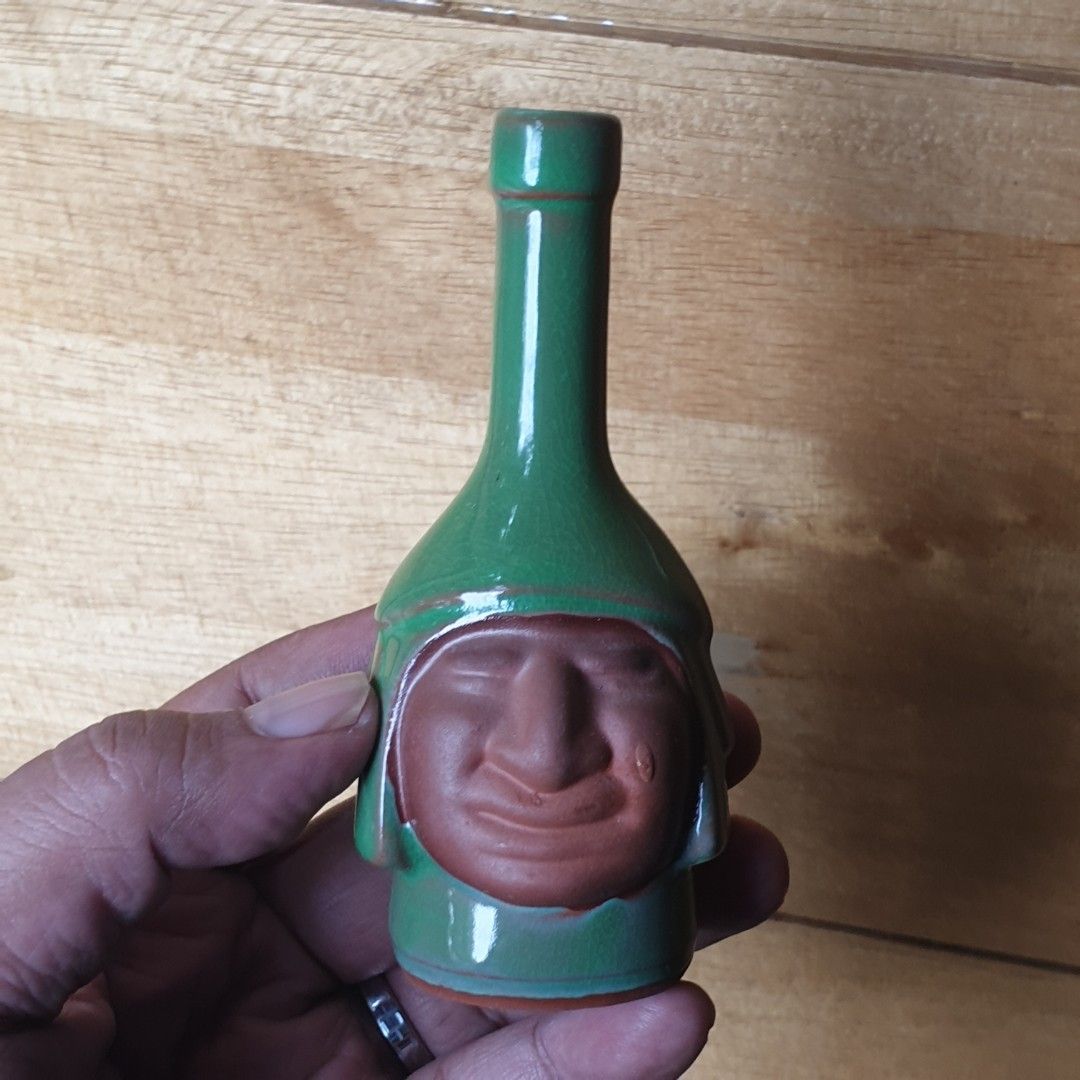 Green Ceramic Bottle with Face Design (Category: Vases & Decorative Bowls) located in Iligan City. Submitted by sariranaw (Listing ID 1463003131, Image 2). Description: - Unique green ceramic - Bottle shape with a carved face - Subtle color variations in glaze - Opening located at the neck - Unglazed terracotta base - Perfect for collectors of quirky items.