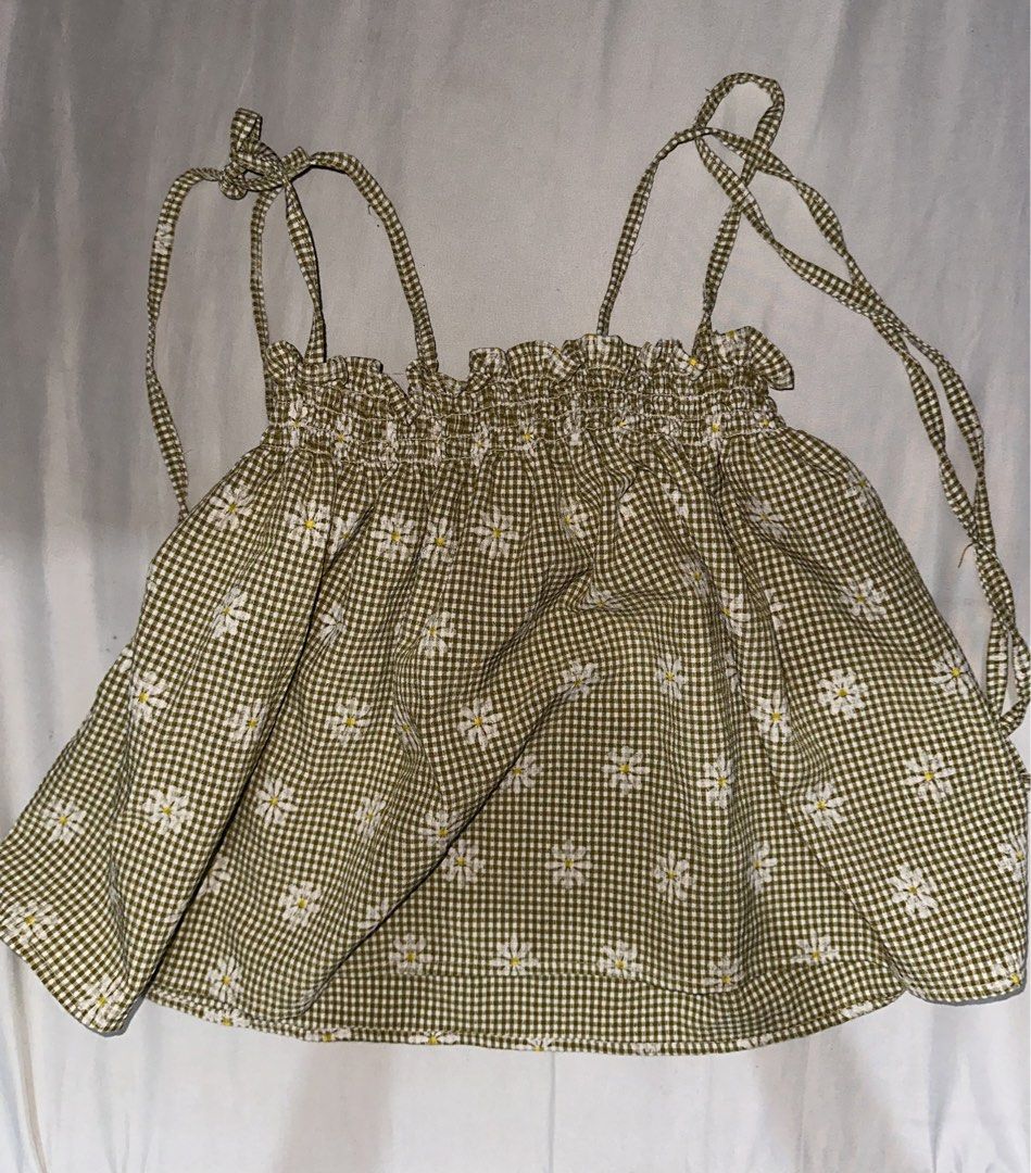 Green Gingham Daisy Print Ruffle Crop Top (Category: Sleeveless) located in Manila. Submitted by etain.xo (Listing ID 1463022856, Image 1). Description: - Adorable green gingham crop top - Features a charming daisy print - Ruffled neckline for a feminine touch - Adjustable tie-up straps - Made from lightweight and flowy fabric - Ideal for summer days and casual outings - Effortlessly pairs with jeans or shorts.