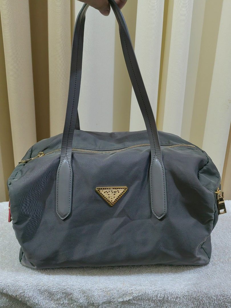 Grey Nylon Leather Tote Bag (Category: Shoulder Bags) located in Makati City. Submitted by prelovedtreatedwithlove (Listing ID 1463003970, Image 1). Description: - Grey tote bag - Material: Nylon with leather trim - Hardware: Gold details - Closure: Zipper - Interior: Spacious main compartment with one zippered pocket - Perfect for: Everyday use or travel -Maganda ang leather quality. Walang rubs - Issue : last pic ung brand nawala. A-146.