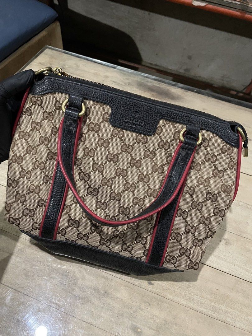 Gucci Monogram Canvas Leather Trimmed Handbag (Category: Luxury Bags & Wallets) located in Buenavista. Submitted by ivoperez27 (Listing ID 1463058094, Image 2). Description: - Gucci handbag - Classic GG monogram canvas - Black leather trim with red piping - Top zip closure - Interior leather tag with serial number 353144 - Black leather handles with red trim - Gold tone hardware - Stylish everyday bag - Issue no sling.