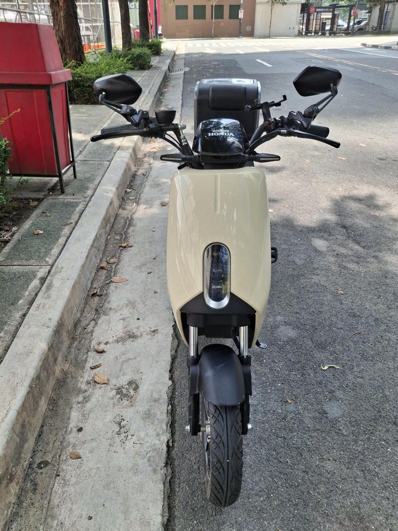 Honda Sundiro S07 with Storage Box (Category: Motorbikes for Sale) located in Taguig. Submitted by queeniekilig (Listing ID 1462919018, Image 2). Description: - Honda S07 Electric Scooter - Stylish cream and grey colorway - Convenient rear storage box - Built-in helmet holder - Ideal for daily city commutes and errands.