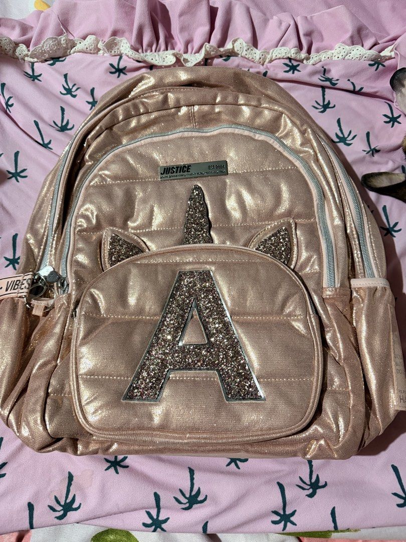 Justice Rose Gold Glitter Unicorn Backpack (Category: Babies & Kids Fashion) located in Cabanatuan. Submitted by styled.shoppe (Listing ID 1463046329, Image 1). Description: - Adorable rose gold backpack from Justice. - Features a sparkly unicorn horn and ears. - Glitter letter 'A' on the front pocket. - Stylish quilted design all over. - Ideal for school or everyday adventures. - Zippers are in excellent working condition. - Adjustable straps fo
