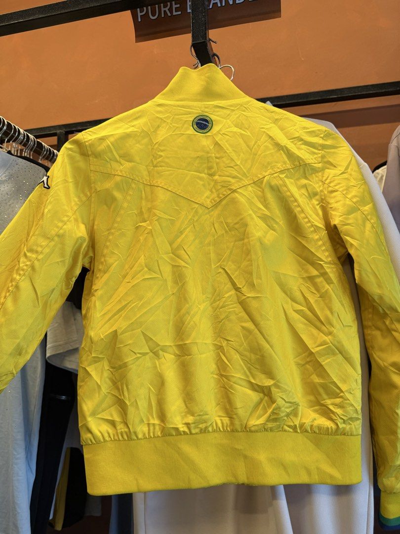 Kappa Brazil Track Jacket Yellow Medium (Category: Coats, Jackets and Outerwear) located in Manila. Submitted by luckyhorse.f804d6 (Listing ID 1462885570, Image 3). Description: - Yellow Kappa track jacket - Size: Medium - 'BRAZIL' and 'Ordem e Progresso' text on the front - Zip-up closure - Pockets included - Kappa logo on sleeve and back - Ideal for casual wear or sports.
