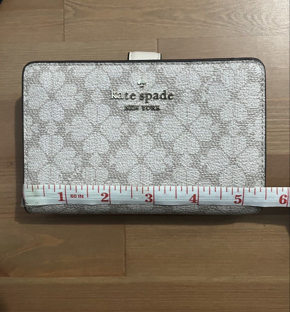 Kate Spade "Spade Flower Jacquard" Wallet (Category: Wallets & Card holders) located in Paranaque City. Submitted by simonthecutecatboy (Listing ID 1463003063, Image 3). Description: - Authentic Kate Spade wallet in Spade Flower Jacquard pattern. - Chic dark beige and cream colorway. - Classic bi-fold style with secure snap closure. - Features ample card slots for organization. - Includes a convenient zip pocket for coins. - Original retail price