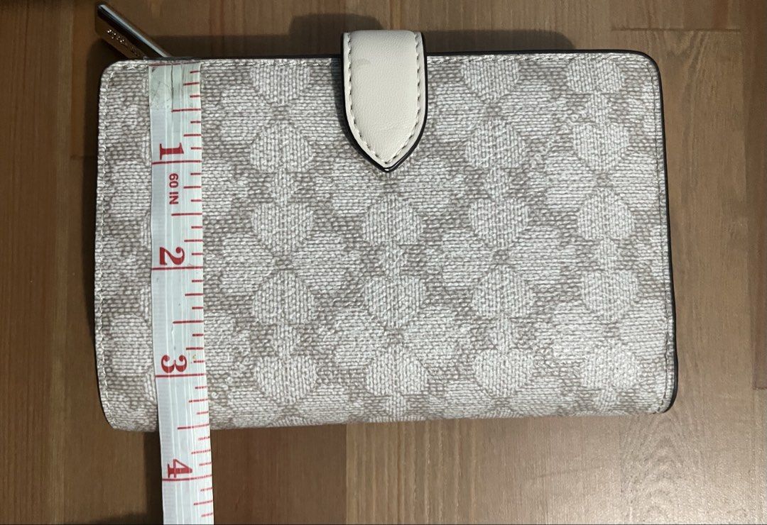 Kate Spade "Spade Flower Jacquard" Wallet (Category: Wallets & Card holders) located in Paranaque City. Submitted by simonthecutecatboy (Listing ID 1463003063, Image 2). Description: - Authentic Kate Spade wallet in Spade Flower Jacquard pattern. - Chic dark beige and cream colorway. - Classic bi-fold style with secure snap closure. - Features ample card slots for organization. - Includes a convenient zip pocket for coins. - Original retail price