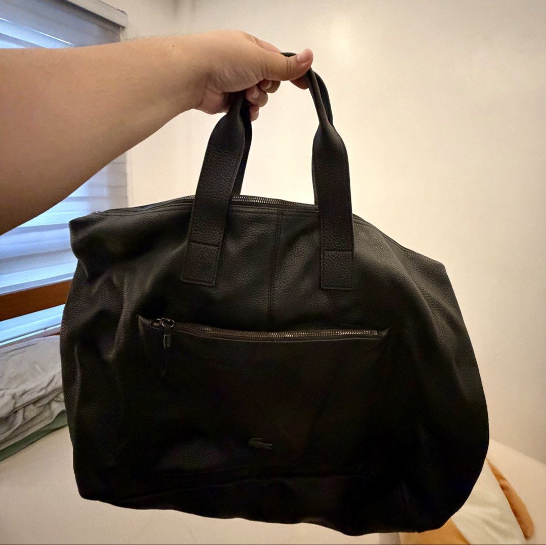 Lacoste Black Leather Tote Bag (Category: Tote Bags) located in Dasmarinas. Submitted by karissaganda (Listing ID 1462993503, Image 2). Description: - Authentic Lacoste black leather tote bag - Spacious main compartment with zipper closure - Exterior zip pocket for quick access - Large front slip pocket - Stylish navy blue interior lining - Comes with original tags - Ideal for travel -bought for 10,990 selling for 4,990.