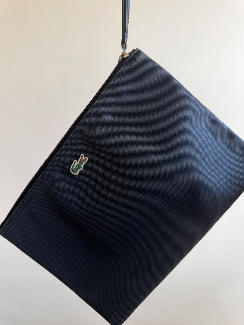 Lacoste Black Pouch with Crocodile Logo (Category: Purses & Pouches) located in Bacolor. Submitted by ieshaaa.1 (Listing ID 1462893005, Image 1). Description: - Authentic Black Lacoste Pouch - Signature Crocodile Logo on Front - Secure Zipper Closure with Leather Pull Tab - Interior Lacoste Branding and Product Tag - Ideal for Organizing Essentials.