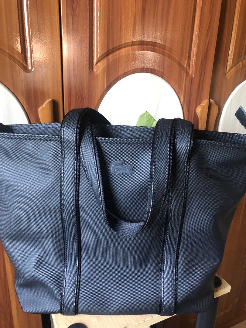 Lacoste Dark Blue-Black Textured Tote Bag (Category: Tote Bags) located in Makati City. Submitted by mitchi_koy28 (Listing ID 1462932598, Image 1). Description: - Classic blue-black Lacoste tote bag - Durable textured material - Spacious interior with zippered pocket - Comfortable shoulder straps - Ideal for everyday use or travel - Simple and functional design - Original bought in store Dimension: Height 12’’ Length 15” Width 4” (top) 6”(bottom)