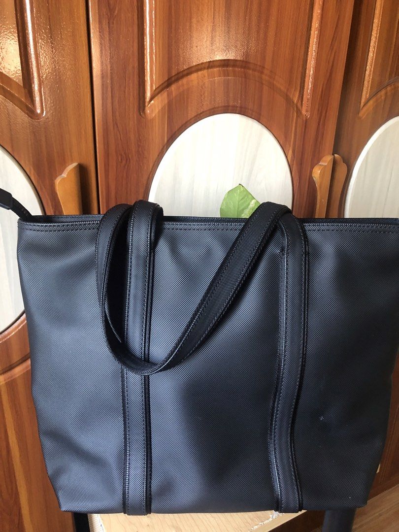 Lacoste Dark Blue-Black Textured Tote Bag (Category: Tote Bags) located in Makati City. Submitted by mitchi_koy28 (Listing ID 1462932598, Image 2). Description: - Classic blue-black Lacoste tote bag - Durable textured material - Spacious interior with zippered pocket - Comfortable shoulder straps - Ideal for everyday use or travel - Simple and functional design - Original bought in store Dimension: Height 12’’ Length 15” Width 4” (top) 6”(bottom)