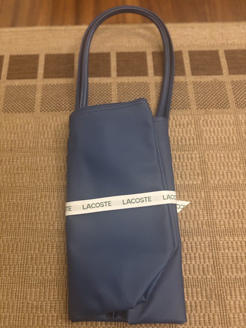 Lacoste Blue Tote Bag with Ribbon (Category: Tote Bags) located in Paranaque City. Submitted by max_bully014 (Listing ID 1462969489, Image 2). Description: - Authentic blue Lacoste tote bag - Comes with original ribbon and tags - Original price tag shows US$110 - Ideal for everyday use - Features a simple and chic design.