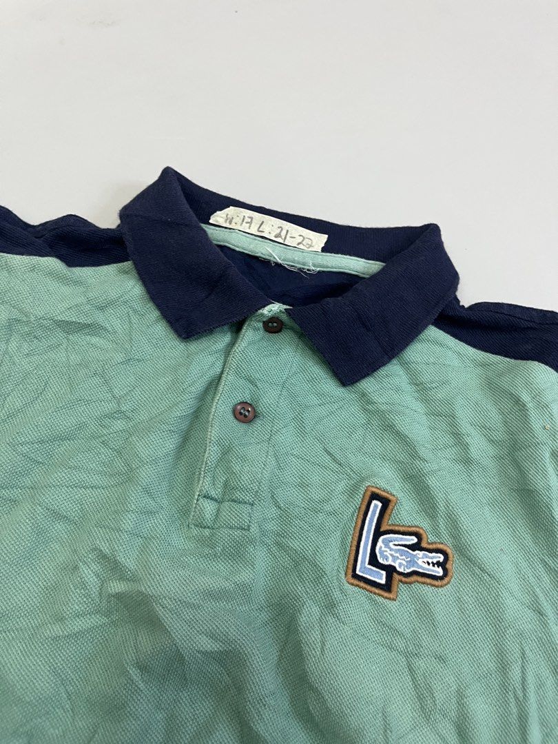 Lacoste Colorblock Polo Shirt (Category: Tshirts & Polo Shirts ) located in Mabalacat. Submitted by aas_thriftfings (Listing ID 1462926196, Image 2). Description: - Classic Lacoste Polo Shirt - Color: Light Green body with Navy Blue sleeves and collar - Features a small embroidered crocodile logo on the chest - Material: 100% Cotton - Ideal for casual wear.
