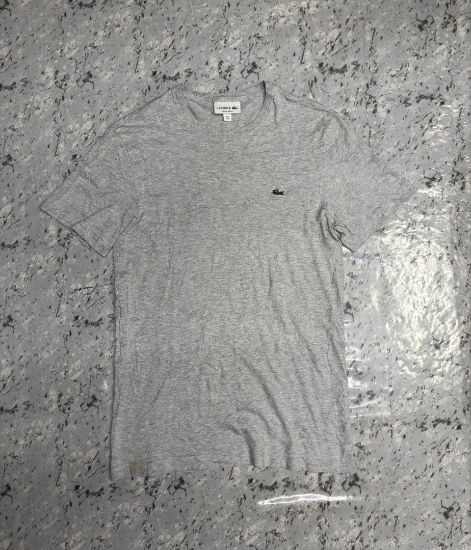 Lacoste Grey T-shirt with Crocodile Logo (Category: Tshirts & Polo Shirts ) located in Manila. Submitted by raven236 (Listing ID 1462899676, Image 1). Description: - Grey Lacoste T-shirt - Features the classic green crocodile logo - Short sleeves, crew neck - Estimated size: Medium (M) - Minor stain on bottom hem (refer to last photo) - Good pre-loved condition.