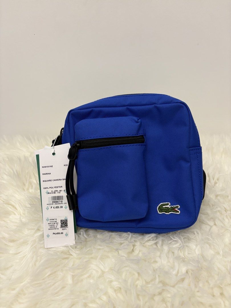 Lacoste Marina Square Camera Bag Blue 100% Polyester (Category: Cross-body Bags) located in Quezon City. Submitted by AAAAAF14 (Listing ID 1463085170, Image 1). Description: - Authentic Blue Lacoste Marina Square Camera Bag - Made of 100% Polyester - Features a front zip pocket and a main zip compartment - Adjustable strap for comfortable wear - Original tag still attached - Original Price: P4,450.00.