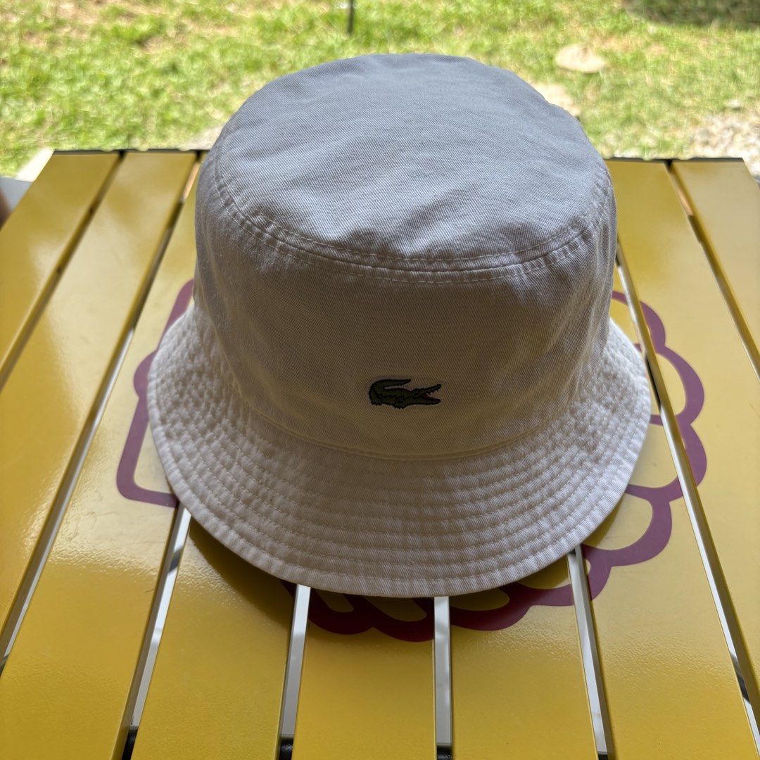 Lacoste White Bucket Hat with Crocodile Logo (Category: Caps & Hats) located in Dapitan. Submitted by payt3es_thrift. (Listing ID 1462936376, Image 1). Description: - Authentic Lacoste white bucket hat - Features iconic embroidered green crocodile logo - Made from comfortable 100% cotton - Ideal for sun protection and stylish everyday wear - Classic, versatile design - Fits most adult head sizes -location Dapitan City, Mindanao .