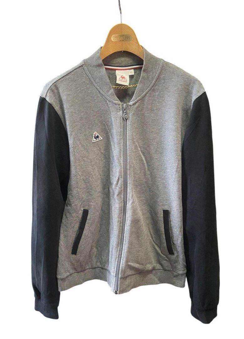 Le Coq Sportif Bomber Jacket Grey Black (Category: Coats, Jackets and Outerwear) located in San Pedro. Submitted by lifebeginsaftercoff33 (Listing ID 1463113355, Image 2). Description: - Le Coq Sportif bomber jacket for Woman - Color: Grey body with black sleeves - Features: Zip-up front, pockets - Detail: Small rooster logo on chest - Condition: Good - Style: Perfect for casual wear - Dimes: 21 x 24 in - Very soft comfy stretchy fabric.