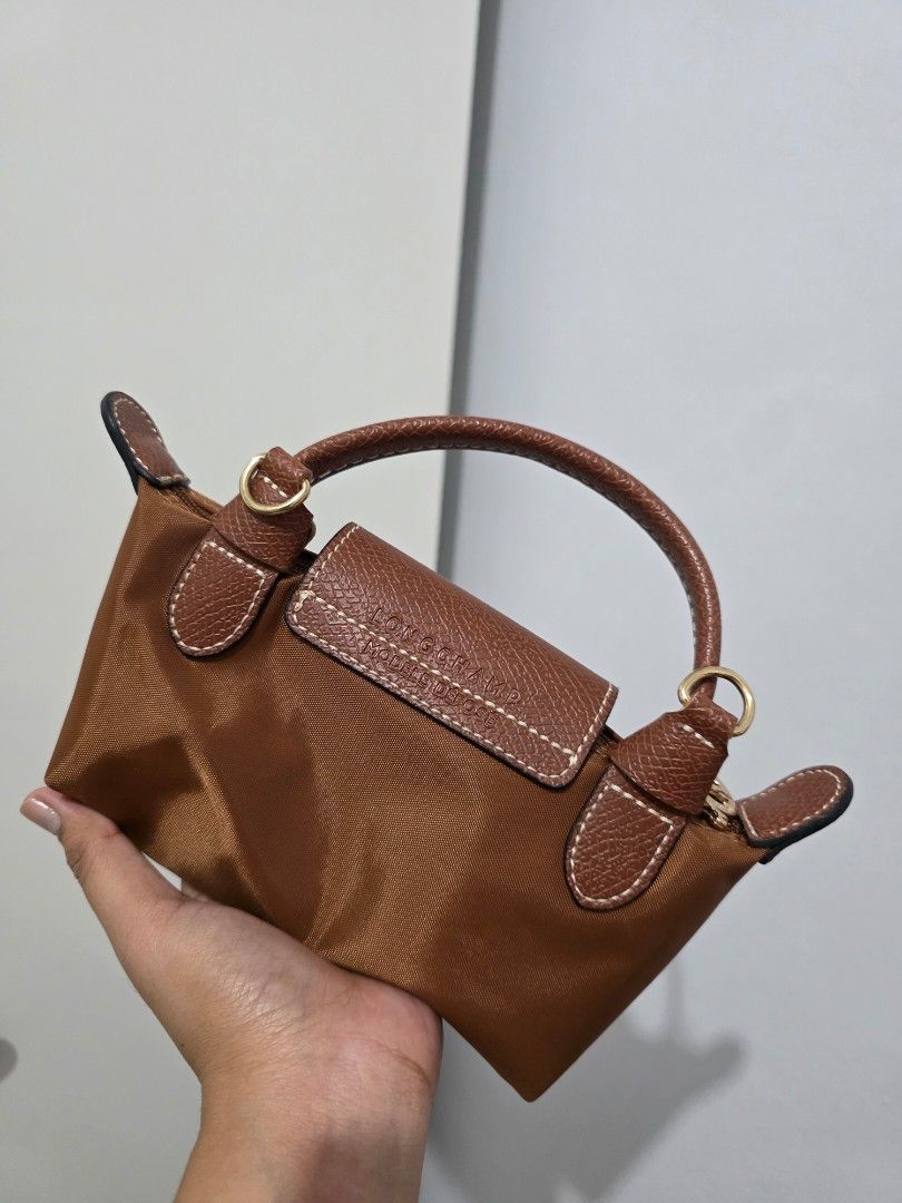 Longchamp Le Pliage Mini in Ebony (Category: Luxury Bags & Wallets) located in Manila. Submitted by decluttaro (Listing ID 1463075550, Image 3). Description: Brown Longchamp handbag. Small size, great for essentials. Leather trim and handles. Detachable shoulder strap included. Zipper closure. Gold hardware details. Very practical and stylish..