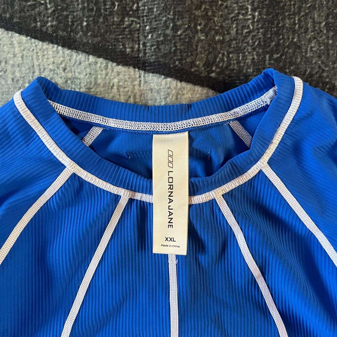 Lorna Jane Blue Ribbed Athletic top (Category: Activewear) located in Cebu City. Submitted by royalwolf-2a85 (Listing ID 1462969919, Image 2). Description: - Brand: Lorna Jane - Color: Blue - Size: XXL - width 18 - length 21 - like New - no issue - Features: Ribbed texture, white piping details, short sleeves, crew neck - Versatile: Great for workouts or casual wear - Origin: Made in China.