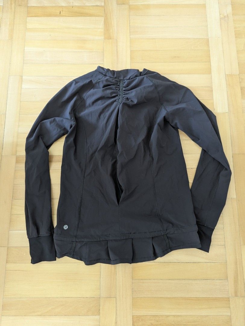 Lululemon Black Hooded Pullover Jacket (Category: Coats, Jackets and Outerwear) located in Taguig. Submitted by hlco13 (Listing ID 1462959268, Image 2). Description: - Black Lululemon athletic jacket - Features a hood for extra coverage - Convenient half-zip closure - Thumbholes on sleeves for a secure fit - Unique gathered detail with a slit opening on the back - Stylish pleated detail on the hem - Versatile for workouts or everyday casual wear.