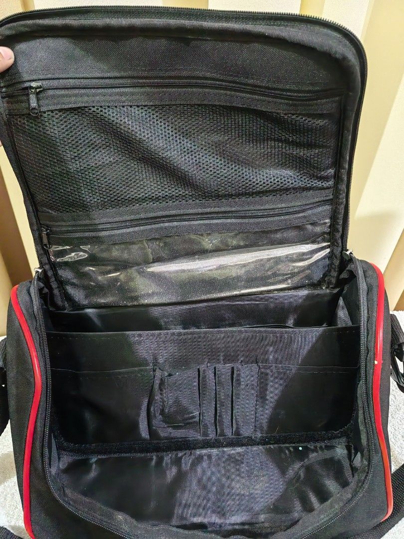 Makeup on the Go Bag with Multiple Compartments (Category: Makeup) located in Makati City. Submitted by prelovedtreatedwithlove (Listing ID 1462975903, Image 2). Description: - Stylish black duffle bag with eye-catching red trim. - Spacious main compartment with built-in organizers for easy packing. - Convenient zippered pocket on the top flap for quick access to essentials. - Handy mesh pocket for storing wet items or water bottles. - Comes with