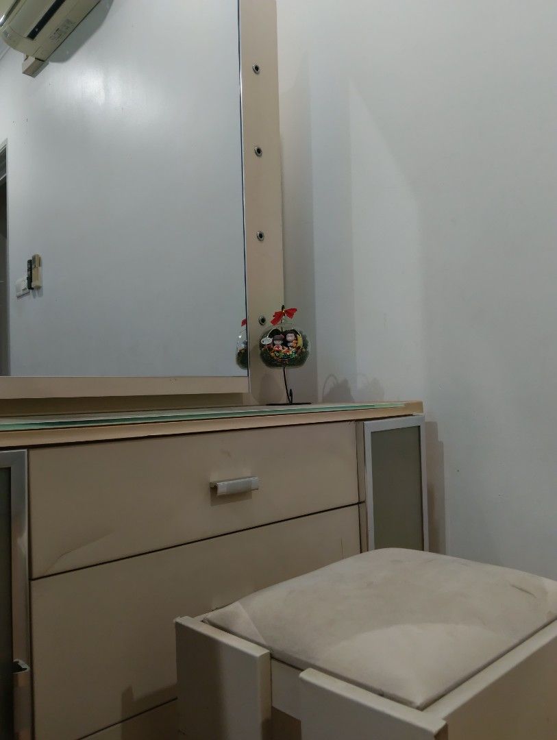 Makeup table (Category: Looking For) located in Kuala Lumpur. Submitted by chua_0947 (Listing ID 1462955233, Image 1). Description: Makeup Table:Buy table free chair 💺 A professional product photograph of a modern wooden makeup vanity table set against a minimalist off-white wall. The vanity features a large rectangular center mirror, a light beige wood laminate finish, and a smooth glass top surface. It has one wide middle drawer with a sleek s