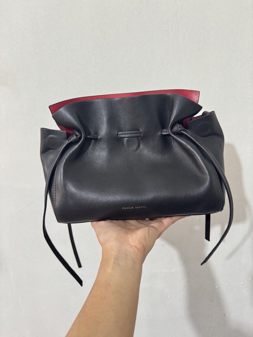 Mansur Gavriel Mini Protea Bag (Category: Luxury Bags & Wallets) located in Manila. Submitted by wildriver.03c46c (Listing ID 1462975328, Image 3). Description: - Brand: Mansur Gavriel - Color: Black leather exterior, bright red interior - Closure: Magnetic - Strap: Adjustable shoulder strap - Details: Gold embossed logo on front - Features: Spacious, ideal for everyday use First pic for reference only. (Smaller bag) Can be used as clutch/crossbo