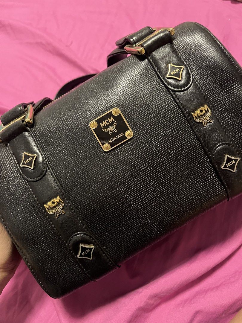 MCM München Black Leather Boston Bag (Category: Luxury Bags & Wallets) located in Bacoor. Submitted by lovedbybhellaiii (Listing ID 1457099005, Image 2). Description: - Authentic MCM Boston Bag - Textured Leather with Gold Hardware - Iconic MCM Logo Plaque and Emblems - Secure Zipper Closure - Comfortable Top Handles for Carrying - A Timeless and Classic Piece Just send me DMs for more detailed pic.