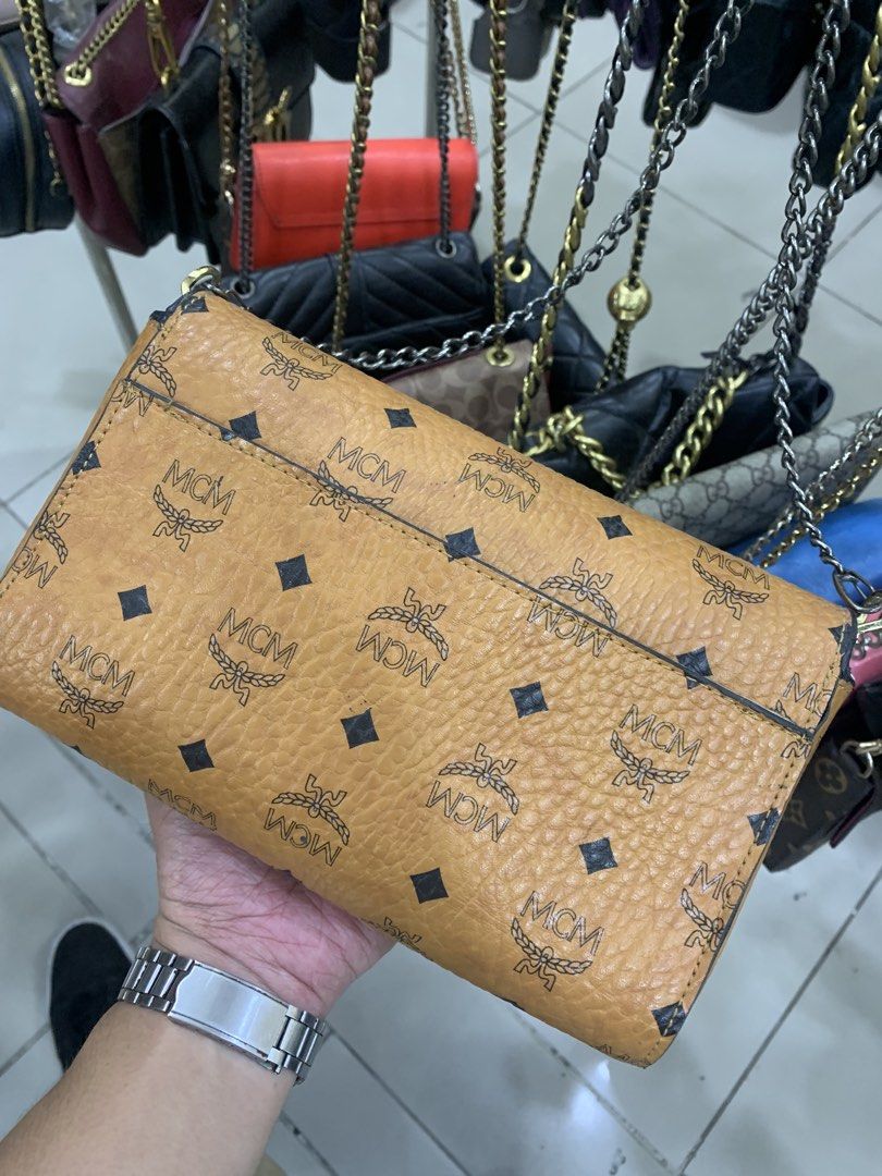 MCM Monogrammed Leather Shoulder Bag (Category: Luxury Bags & Wallets) located in Bacolod City. Submitted by jmthrift28 (Listing ID 1463005476, Image 3). Description: - Authentic brown MCM shoulder bag - Signature monogram print - Gold-tone hardware and chain strap - Secure flap closure with clasp - Interior zippered pocket - Versatile for everyday or evening wear.