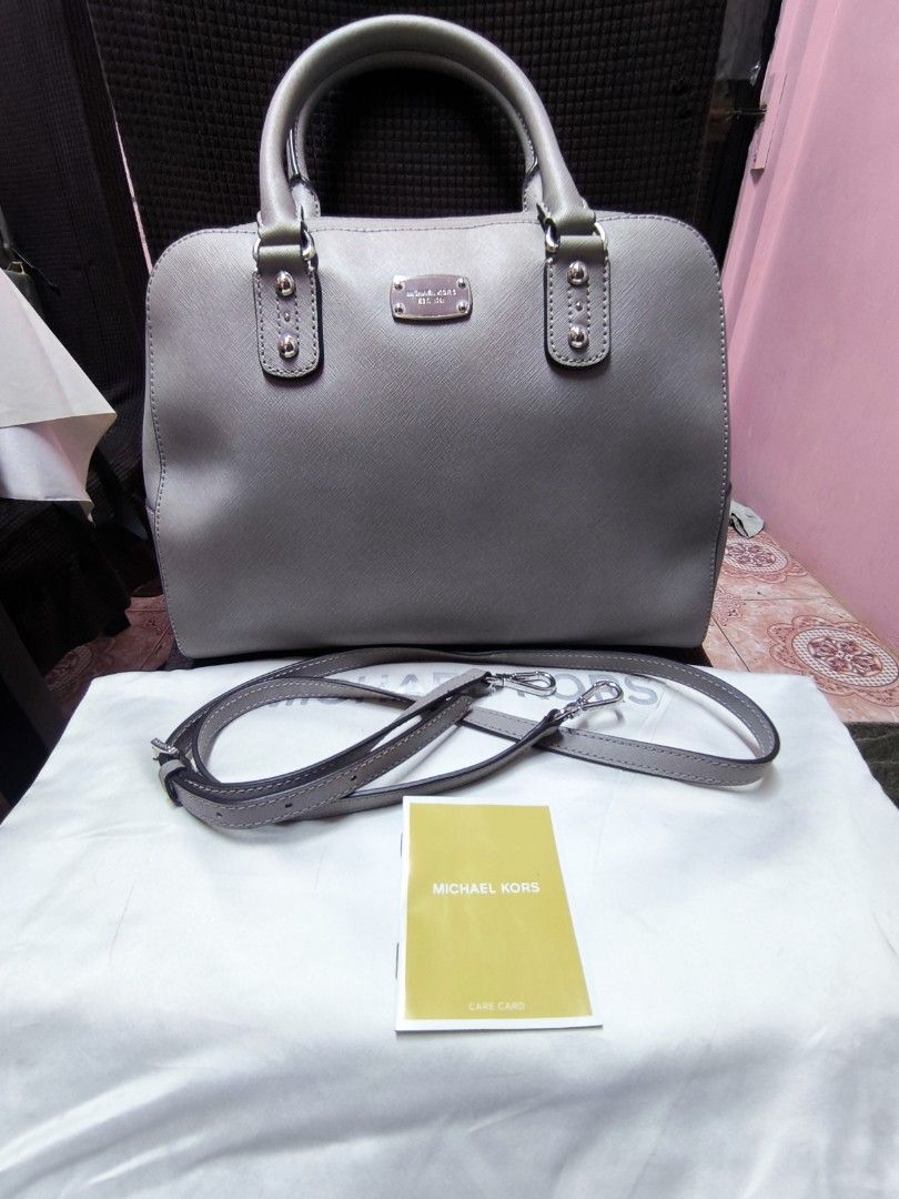 Michael Kors Grey Leather Satchel Bag with Strap (Category: Luxury Bags & Wallets) located in Valenzuela. Submitted by puretiger.eb3a79 (Listing ID 1462922368, Image 3). Description: - Authentic Michael Kors grey leather satchel bag - Features top handles and an adjustable shoulder strap for versatile carrying - Spacious interior with multiple compartments and secure zip pockets - Bag is clean inside and out, well-maintained - Comes with the orig