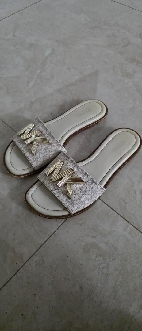 Authentic Michael Kors MK Logo Slides Sandals (Category: Sneakers & Footwear) located in Angeles City. Submitted by miho066_ (Listing ID 1462987867, Image 2). Description: - Authentic Michael Kors slides - Iconic MK logo pattern - Chic cream and gold colorway - Easy slip-on design - Comfortable footbed with embossed Michael Kors logo - Ideal for everyday casual wear.