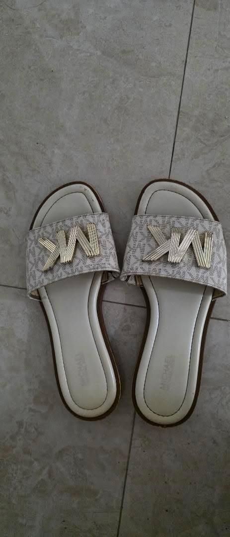 Authentic Michael Kors MK Logo Slides Sandals (Category: Sneakers & Footwear) located in Angeles City. Submitted by miho066_ (Listing ID 1462987867, Image 1). Description: - Authentic Michael Kors slides - Iconic MK logo pattern - Chic cream and gold colorway - Easy slip-on design - Comfortable footbed with embossed Michael Kors logo - Ideal for everyday casual wear.