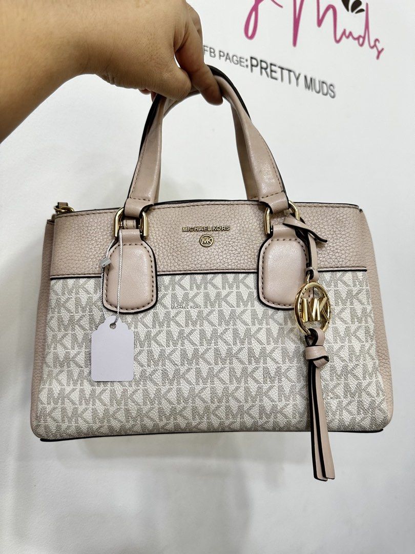 Michael Kors Monogram Satchel Bag (Category: Luxury Bags & Wallets) located in Cardona. Submitted by jaxdelossa10453 (Listing ID 1463006465, Image 1). Description: - Authentic Michael Kors satchel bag -missing strap - Classic beige and white MK monogram print - Elegant textured leather trim in a light pinkish-beige hue - Stylish gold hardware accents - Comfortable top handles - Includes a detachable charm for added flair - Ideal for everyday wear